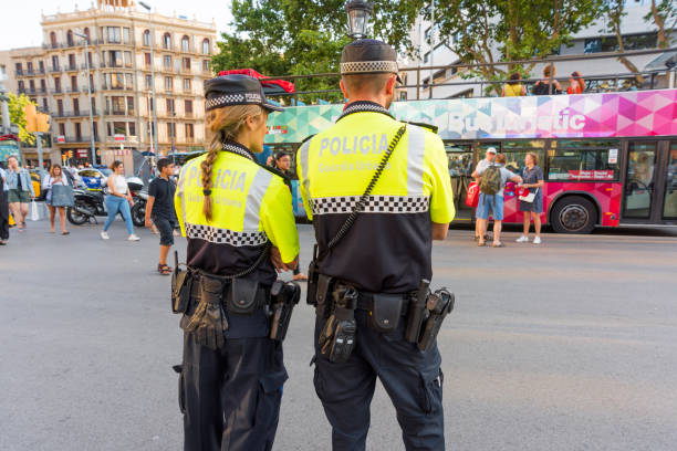 Policeman and Policewoman in Barcelona, Spain 'Barcelona, Spain- jun 1, 2017: Policeman and Policewoman standing on the street in Barcelona, Spain, observing people and doing their job police policewoman women spain stock pictures, royalty-free photos & images