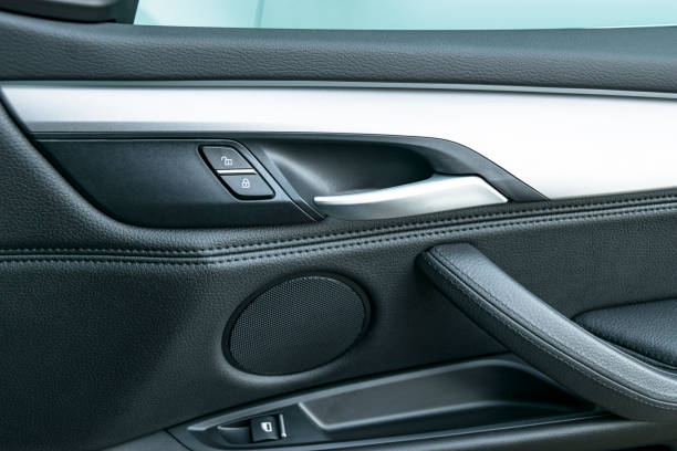 Car door handle inside the luxury modern car with black leather and switch button control, modern car interior details