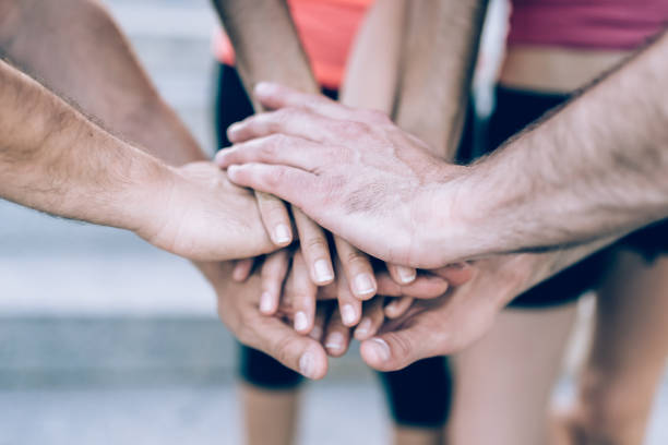 istock sports people holding hands in a huddle 807499832