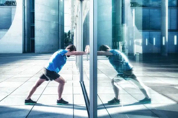 Photo of bearded sportsman pushing against glass