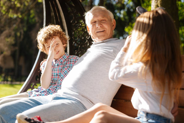 istock Funny children making faces while being near their grandpa 807500176