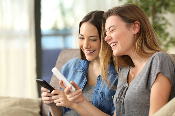 istock Girls laughing watching media content on line 807511528
