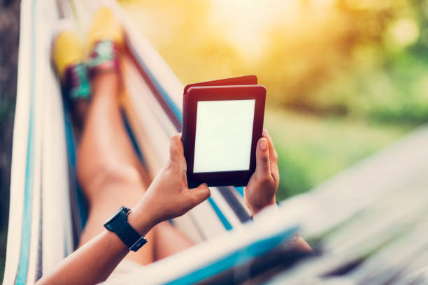 Relaxed girl in hammock reading an e-book