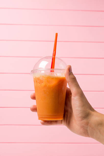 istock Lemonade in plastic glass with fruit in hand 807529660