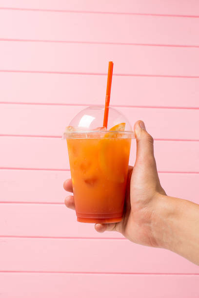 istock Lemonade in plastic glass with fruit in hand 807530322