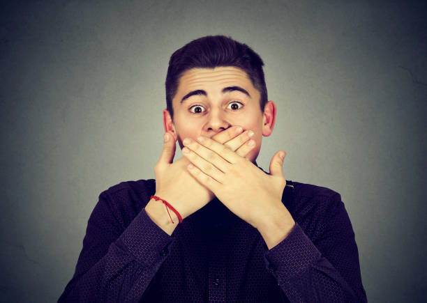 istock Scared man covering mouth with hands 807539034