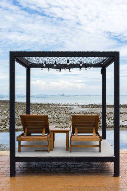 istock Two wooden chairs on rock beach in Chonburi, Thailand 807582504