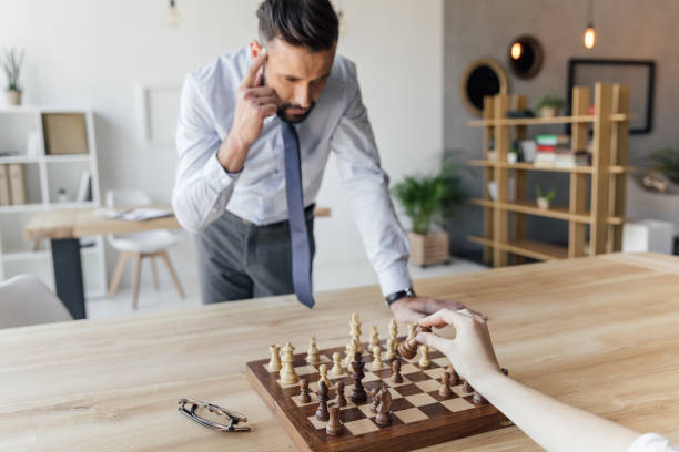 istock focused businessman playing chess with colleague in office 807594692