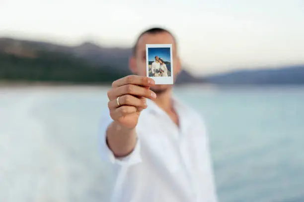 Photo of Young man showing instant photo