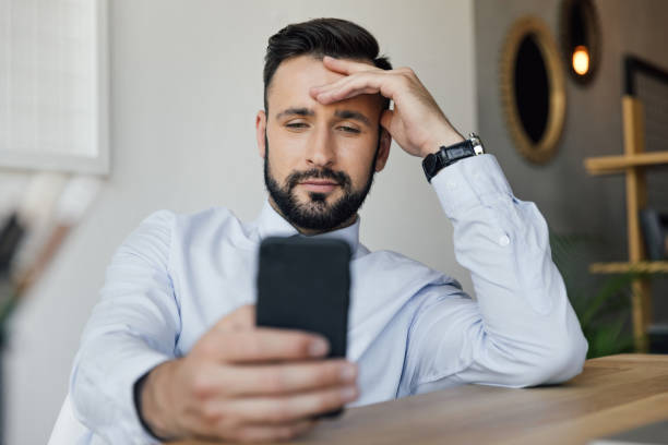 istock portrait of smiling businessman using smartphone while sitting at workplace 807602460