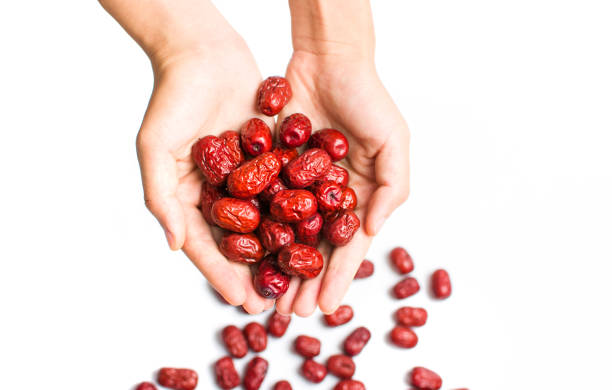 Hand holding Chinese red dates isolated