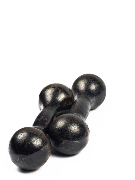 istock Two vintage cast iron black dumbbells stacked in parallel, on a white background 807660622