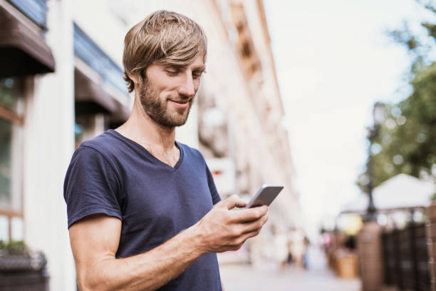 istock Handsome young man using smart phone outdoors 807690844