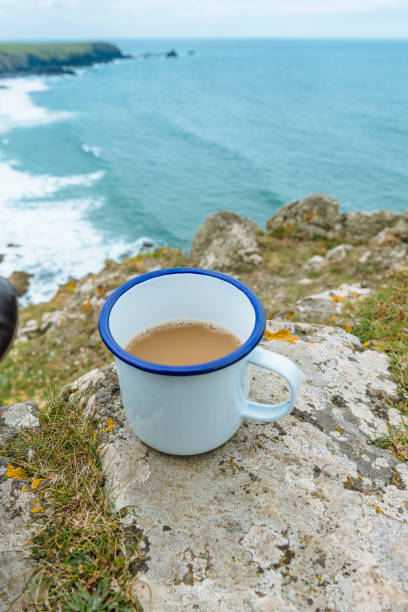 istock Metal mug full of tea on the cliffs above the Cornish Coast. 807742090