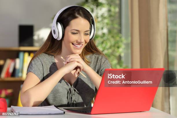 Student Watching Video Tutorials On Line Stock Photo - Download Image Now - E-Learning, Red, Laptop