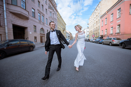 Wedding couple on the nature is walking. Beautiful model girl in white dress. Handsome man in suit. Beauty bride with groom. Female and male portrait. Woman with lace veil. Lady and guy outdoors