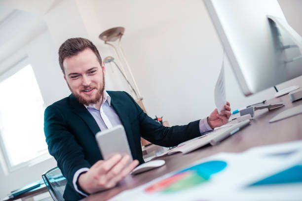 istock Smiling Businessman Checking his Smartphone in the Office 807748730