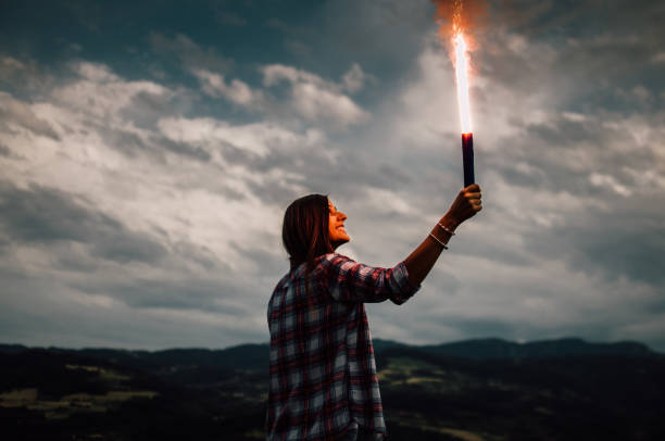 istock Girl with torch on mountain 807754432