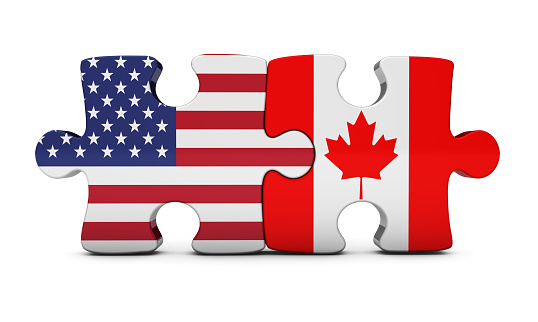 USA and Canada bilateral cooperation and trading relations concept with US and Canadian flag on puzzle pieces 3D illustration on white background.