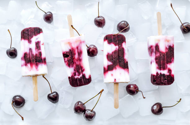 istock Yogurt and cherries popsicles on ice cubes. Refreshing summer dessert. 807770052