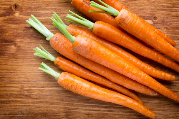 istock Fresh carrots on the wooden background. 807784656