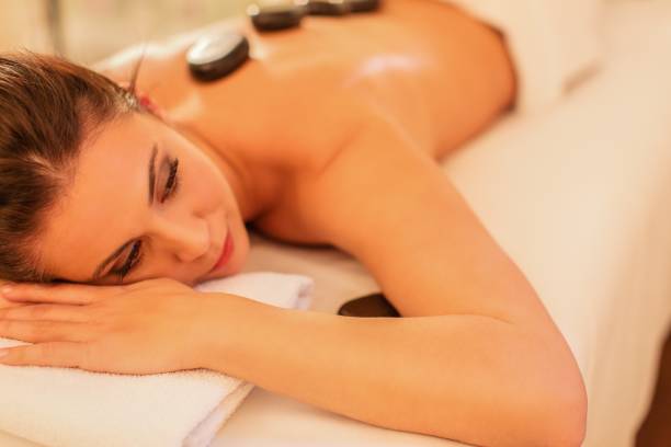istock Woman having therapy with hot stones 807827620