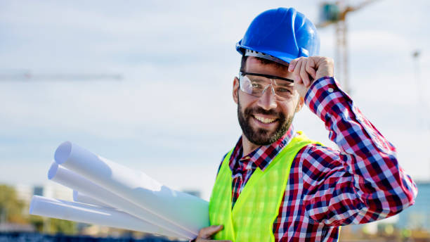 istock Young engineer with blue print wearing helmet 807836276