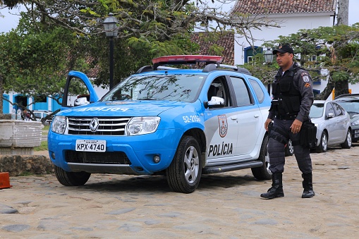 Police officer walks next to Renault Duster police car in Paraty (state of Rio de Janeiro). PMERJ state police employs 52,000 people.