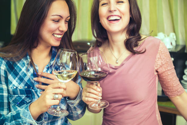 istock Happy girls drinking wine and laughing. 807837348