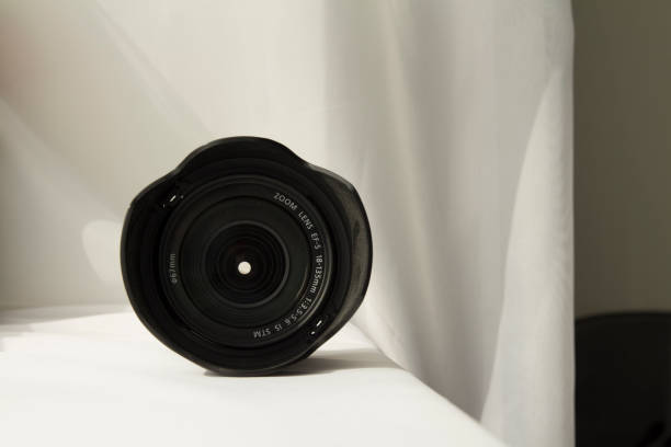 istock Black camera zoom lens on white cloth 807844830