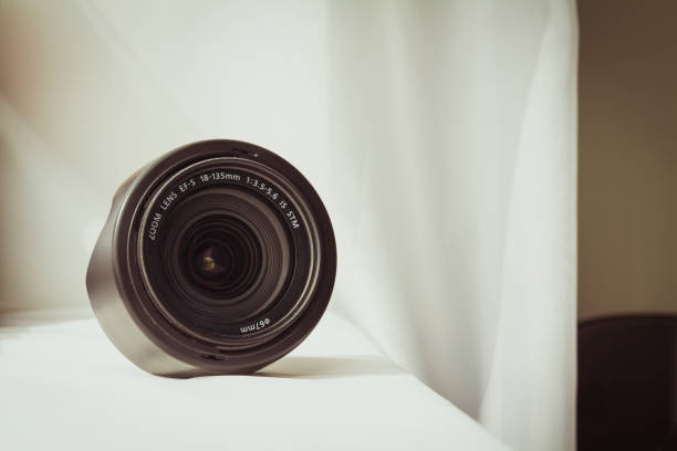 istock Black camera zoom lens on white cloth 807844920