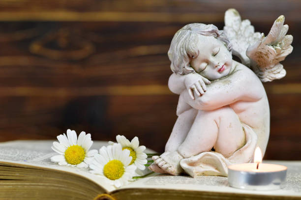 istock Angel, candle and flowers 807847588