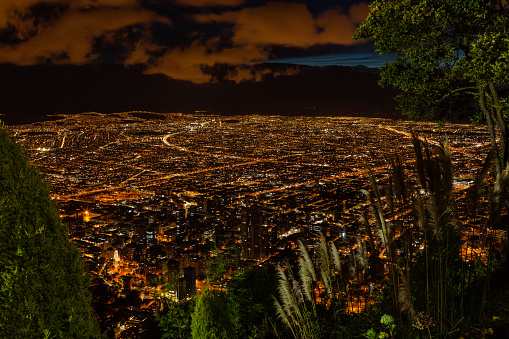 Bogota, Colombia - Looking at the Andean capital city of Bogota, Colombia in South America, from the mountain peak called Monserrate after sunset. Street lights have come on and headlights and tail-lights of vehicles are just streaks of lights due to the extended time exposure. To the bottom of the image is the downtown district of the City. Those who know the city, can easily recognise landmarks and principal plazas. Located at about 8500 feet above mean sea level, with a population of almost 10 Million, Bogota is one of the largest cities in Latin America. The main square, Plaza Bolivar, with the parliament building, can be clearly seen - left of centre. Photo shot in the Blue Hour at an elevation of about 1800 feet above the City; horizontal format. Camera: Canon EOS 5D MII. Lens: Canon EF 24-70 F2.8L USM.