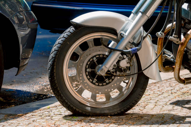 Security number padlock blocking motorcycle wheel on the street.
