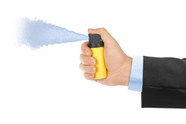 Hand with bottle of pepper spray Hand with bottle of pepper spray isolated on white background tear gas can stock pictures, royalty-free photos & images