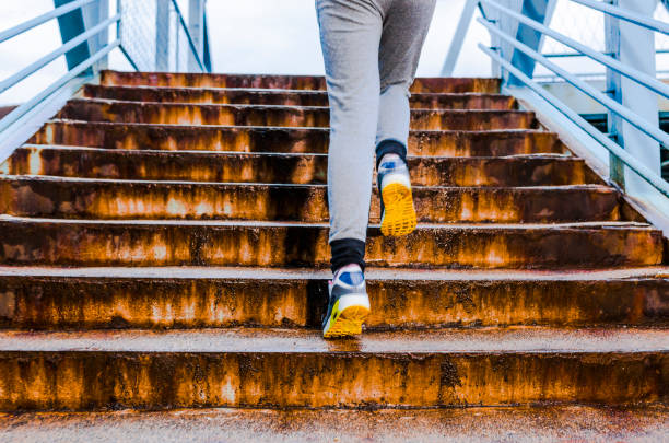 istock Young woman running up stairs 807875076