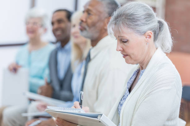 istock Senior woman takes notes during seminar 807900496