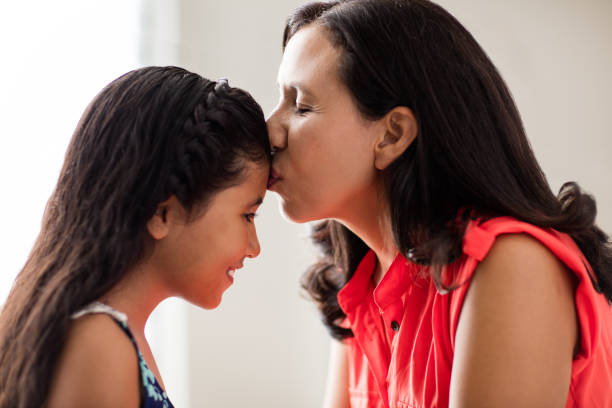 istock Latin mother kissing daughter's forehead 807903474