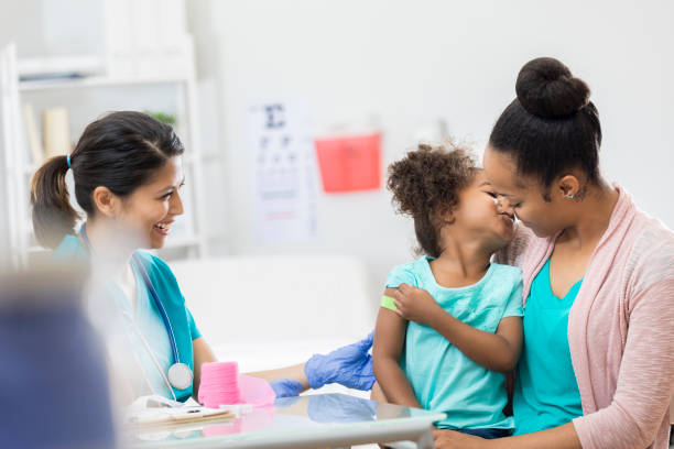 istock Mom comforts daughter after receiving an immunization 807903510