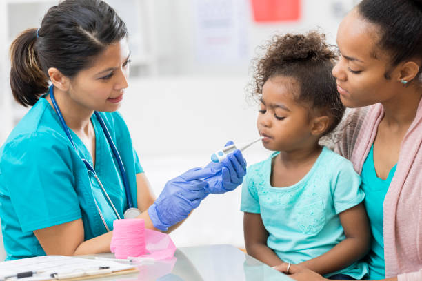 istock Nurse uses a digital thermometer to check young patient's temperature 807903560