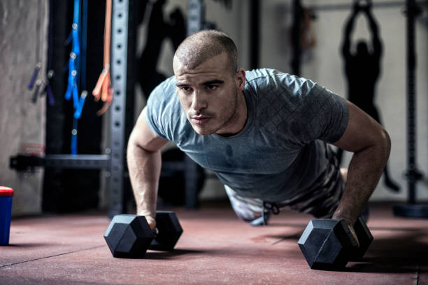 istock Push ups on dumbbells in gym 807909634