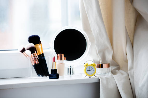 istock professional makeup set, alarm clock and cute mirror on the wonderful white windowsill 807953414