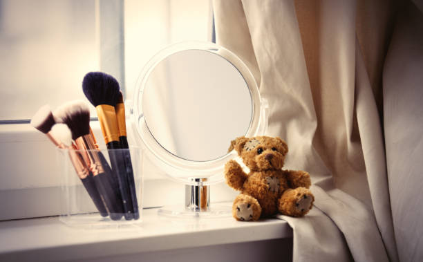 istock professional makeup brushes in glassy box, teddy bear and cute mirror on the wonderful white windowsill 807953464