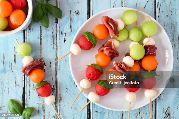 Plate Of Summer Fruit Skewers On A Rustic Blue Wood Background Stock Photo - Download Image Now