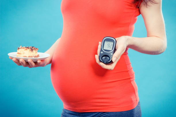 mujer embarazada con medidor de glucosa con el nivel de azúcar de buen resultado y pedazo de cheesecake, diabetes y nutrición durante el embarazo - diabetes human pregnancy women blood sugar test fotografías e imágenes de stock