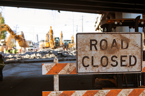 Worn Road Closed barricade blocks road at Atlanta collapsed interstate bridge construction site.