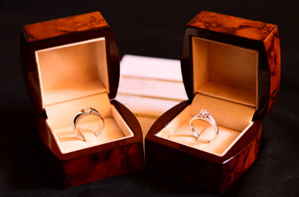 Platinum Diamond Ring, Wedding rings in a box on dark background with warranty card blurred