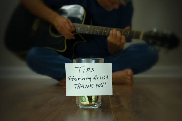 Starving artist guitarist street performer with tip cup jar stock photo