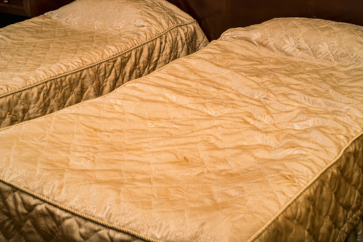 Closeup picture of two neatly done beds in hotel room