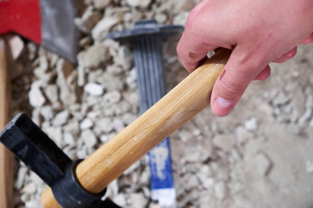istock A hand holding hammer on the background of work tools and rubble 808078976